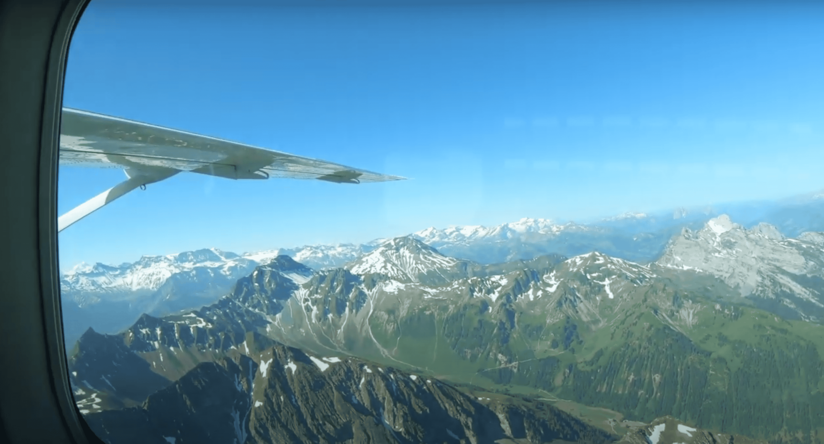 A passenger took a photo in a skydiving plane overlooking all of the beautiful mountains in the Interlaken area. 